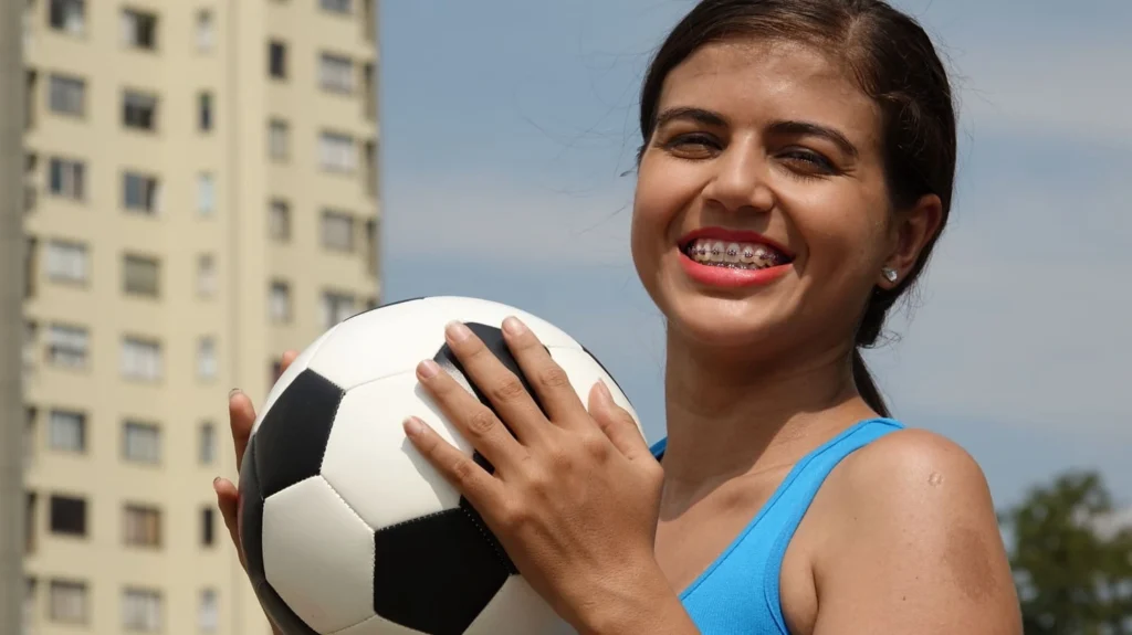 Teen athlete wearing braces while playing football